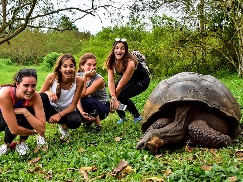 Santa Cruz II's guests with a Galapagos giant tortoise.